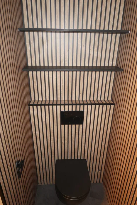 Toilet met houten lamellenwanden, zwart hangtoilet, zwarte drukplaat en zwarte wandplanken